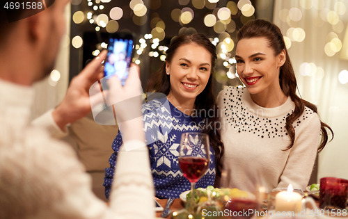 Image of friends having christmas dinner and taking picture