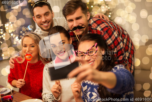 Image of friends taking selfie at christmas dinner