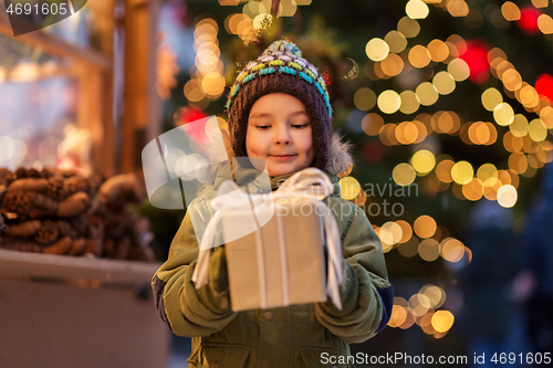 Image of happy boy with gift box at christmas market