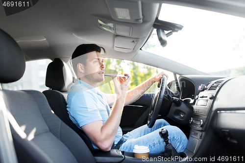 Image of man driving car and recording voice by smartphone