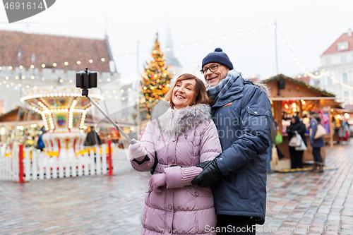 Image of senior couple taking selfie at christmas market