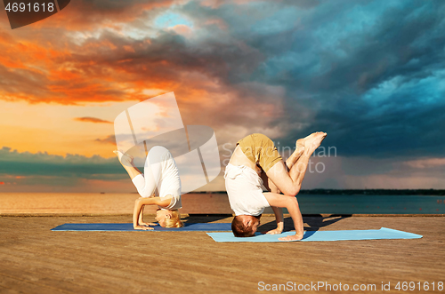 Image of couple making yoga outdoors