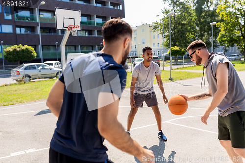 Image of group of male friends playing street basketball