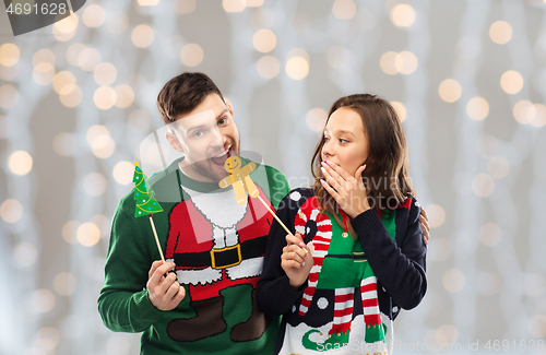 Image of couple with christmas party props in ugly sweaters