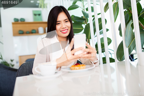 Image of asian woman with smartphone at cafe or coffee shop