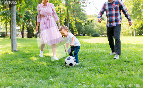 Image of happy family playing soccer at summer park