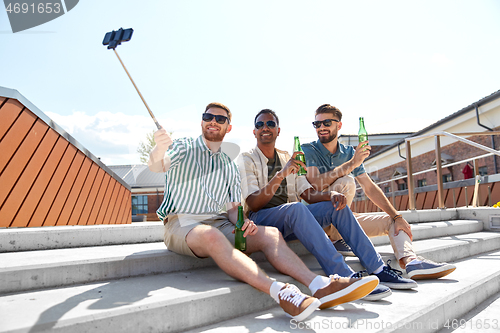 Image of men drinking beer and taking selfie by smartphone