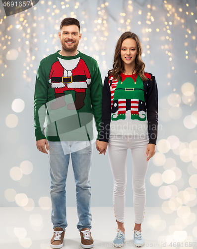 Image of happy couple at christmas ugly sweater party