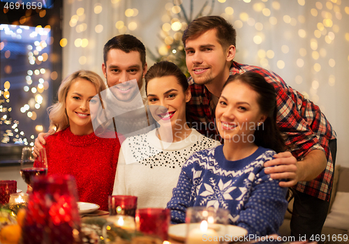 Image of happy friends celebrating christmas at home