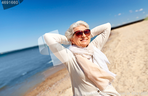 Image of portrait of senior woman in sunglasses on beach