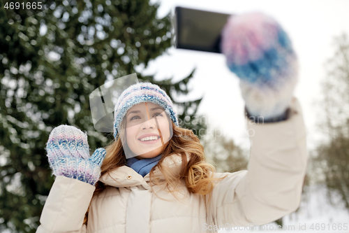 Image of woman taking selfie by smartphone in winter