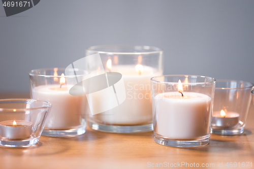 Image of burning white fragrance candles on wooden table