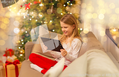 Image of smiling girl with tablet pc at christmas home