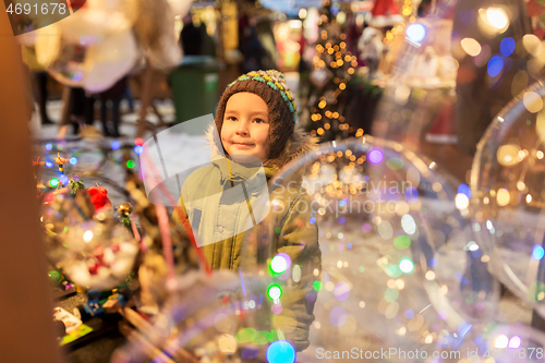 Image of happy little boy at christmas market in winter