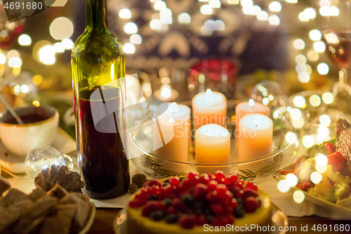 Image of food, drinks and candles burning on table