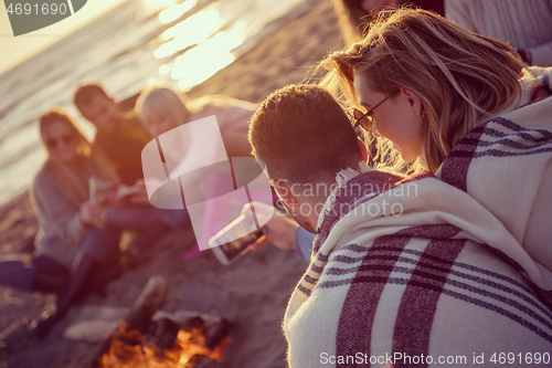 Image of Friends having fun at beach on autumn day