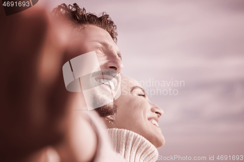 Image of Loving young couple on a beach at autumn sunny day