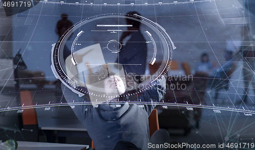 Image of businessman sitting with legs on desk at office