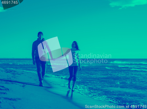 Image of Loving young couple on a beach at autumn sunny day