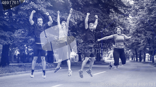 Image of runners team jumping in the air during  morning training