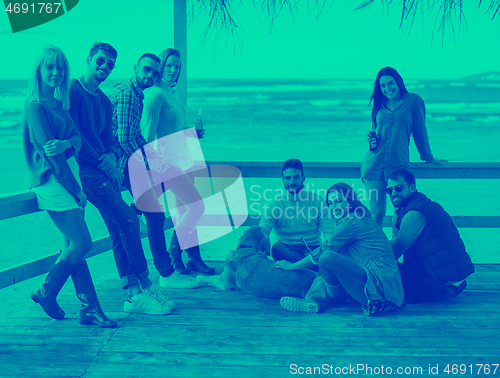 Image of Group of friends having fun on autumn day at beach