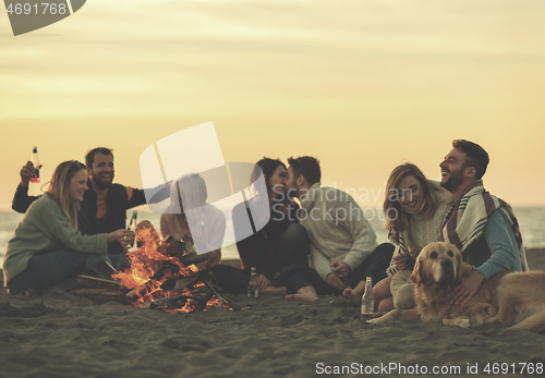 Image of Friends having fun at beach on autumn day