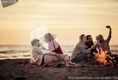 Image of Friends having fun at beach on autumn day