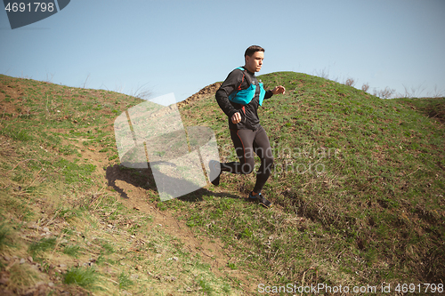 Image of Man running in a park or forest against trees background.