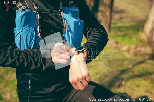 Image of Man preparing tu run in a park or forest against trees background.