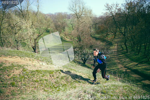 Image of Man running in a park or forest against trees background.