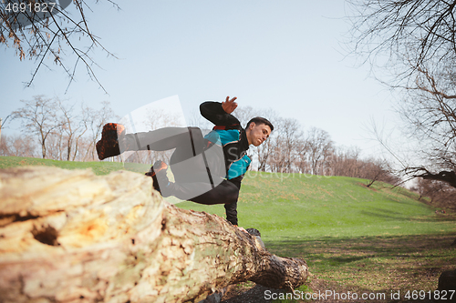 Image of Man running in a park or forest against trees background.