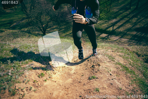 Image of Man running in a park or forest against trees background.