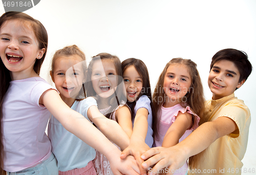 Image of The portrait of cute little boy and girls in stylish clothes looking at camera at studio