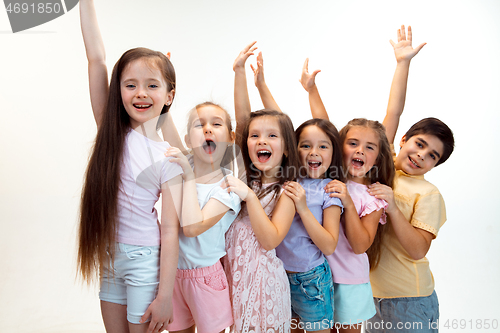 Image of The portrait of cute little boy and girls in stylish clothes looking at camera at studio