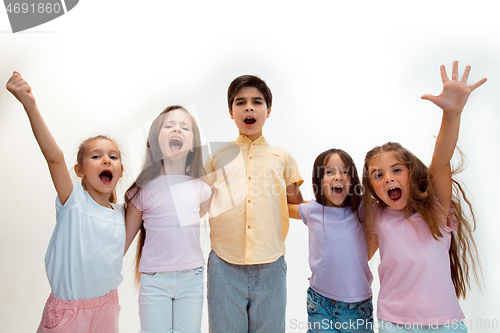 Image of The portrait of cute little boys and girls in stylish clothes looking at camera at studio