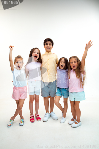 Image of The portrait of cute little boys and girls in stylish clothes looking at camera at studio