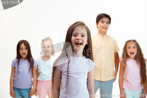 Image of The portrait of cute little boys and girls in stylish clothes looking at camera at studio