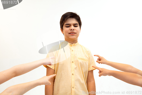 Image of Little boy standing alone and suffering an act of bullying.