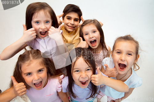 Image of The portrait of cute little boy and girls in stylish clothes looking at camera at studio