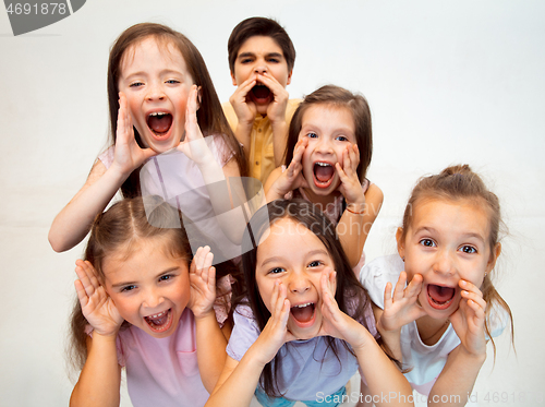 Image of The portrait of cute little boy and girls in stylish clothes looking at camera at studio