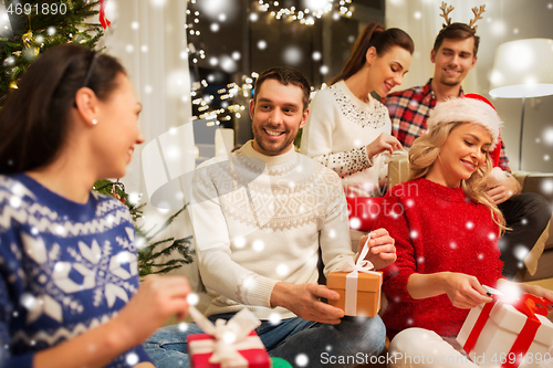 Image of friends celebrating christmas and opening presents