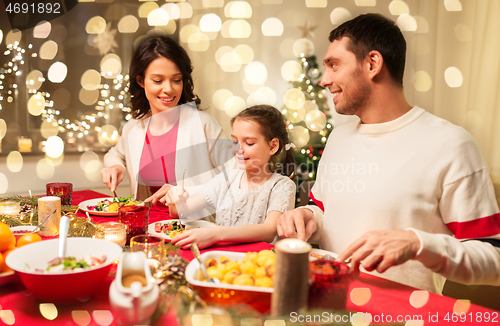 Image of happy family having christmas dinner at home