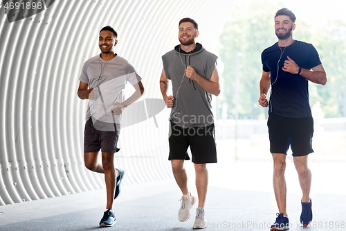 Image of male friends with earphones running outdoors
