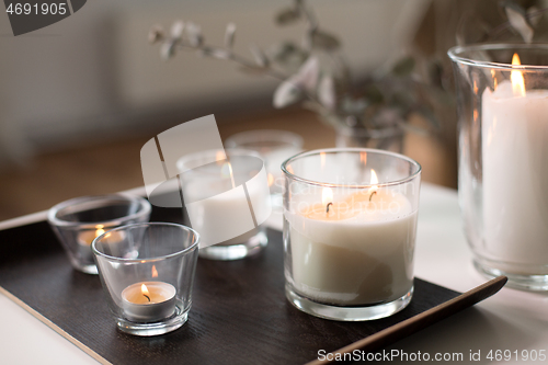 Image of burning fragrance candles on table at cozy home