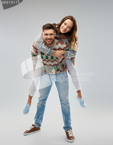 Image of happy couple at christmas ugly sweater party