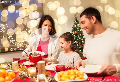 Image of happy family having christmas dinner at home