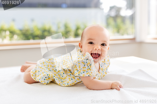 Image of sweet baby girl lying on white blanket