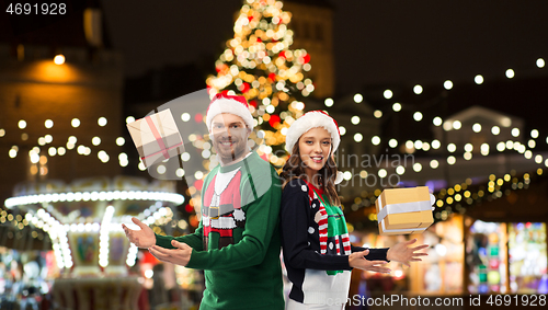 Image of happy couple with gifts at christmas market