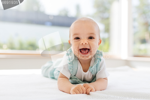 Image of sweet baby girl lying on white blanket