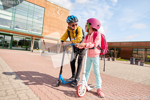 Image of school children with smartphones and scooters